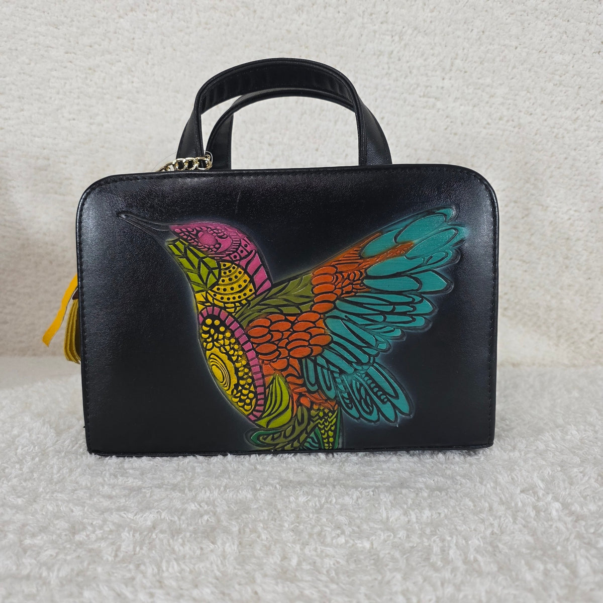 Black handbag with a colorful bird design 