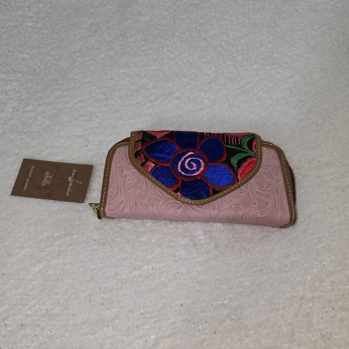 Pink wallet with floral embroidery on a black background