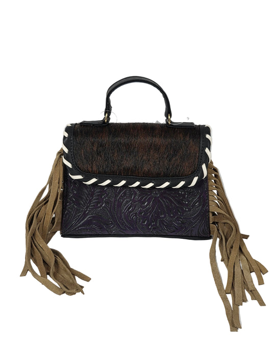 A western-style handbag with a dark brown and black cowhide flap, a purple tooled leather body, white braided trim, and long tan fringe tassels on both sides, shown against a plain white background.